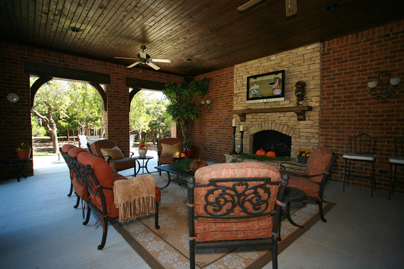 Outdoor living with cedar slat ceiling and stacked-stone fireplace